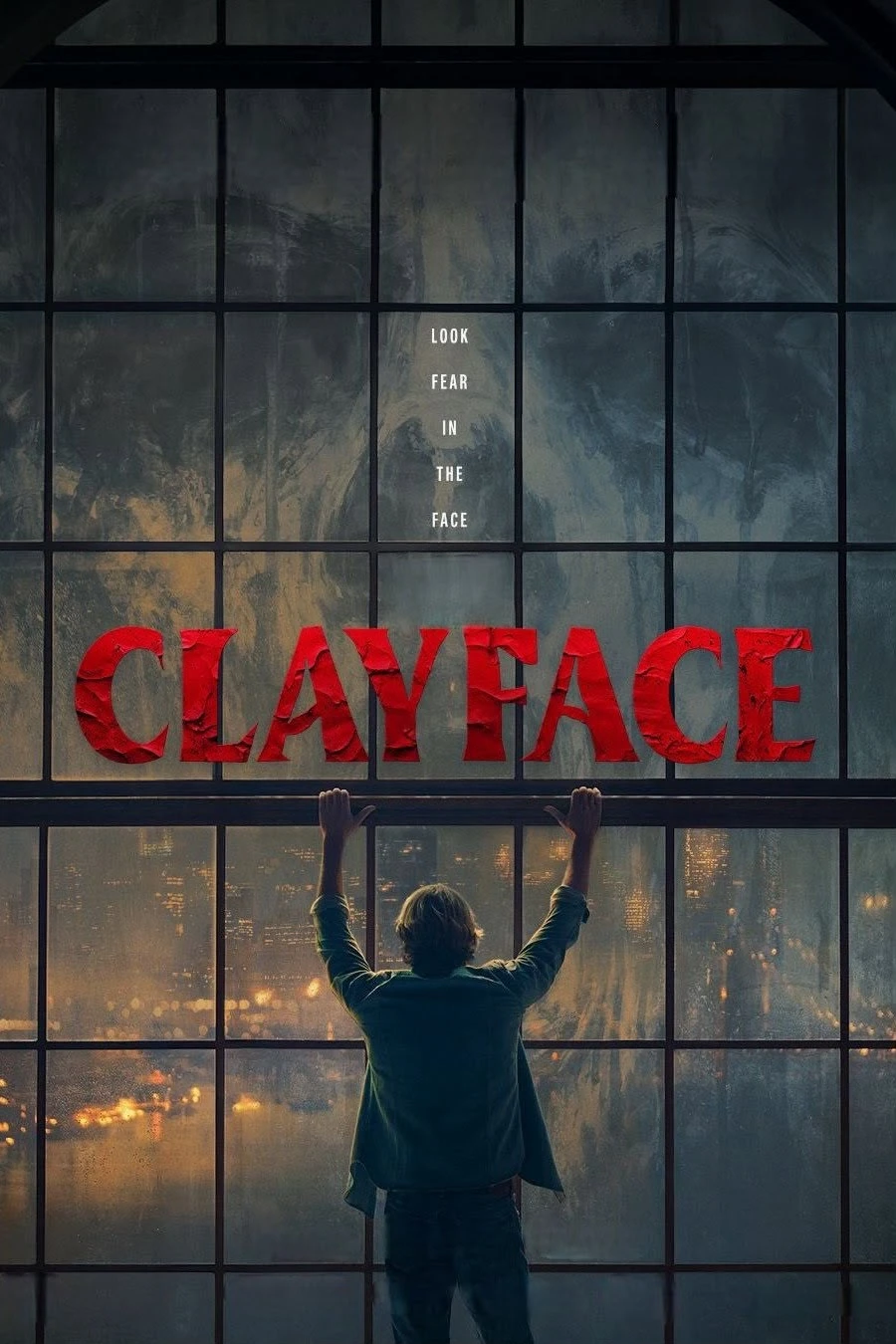 رجل يرفع ذراعيه أمام نافذة شبكية تطل على مدينة ليلية، وعنوان Clayface الأحمر يعبر الزجاج