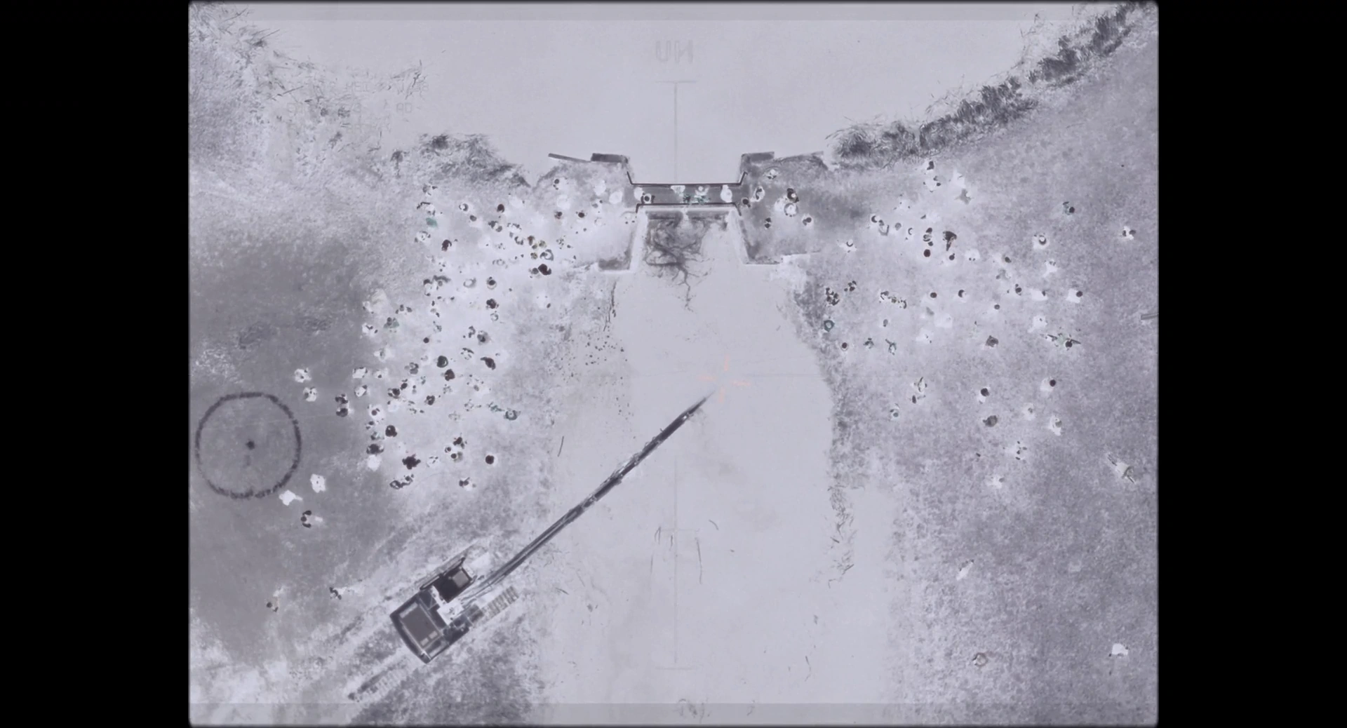 A grey aerial image of rocky ground marked by lines and geometric shapes