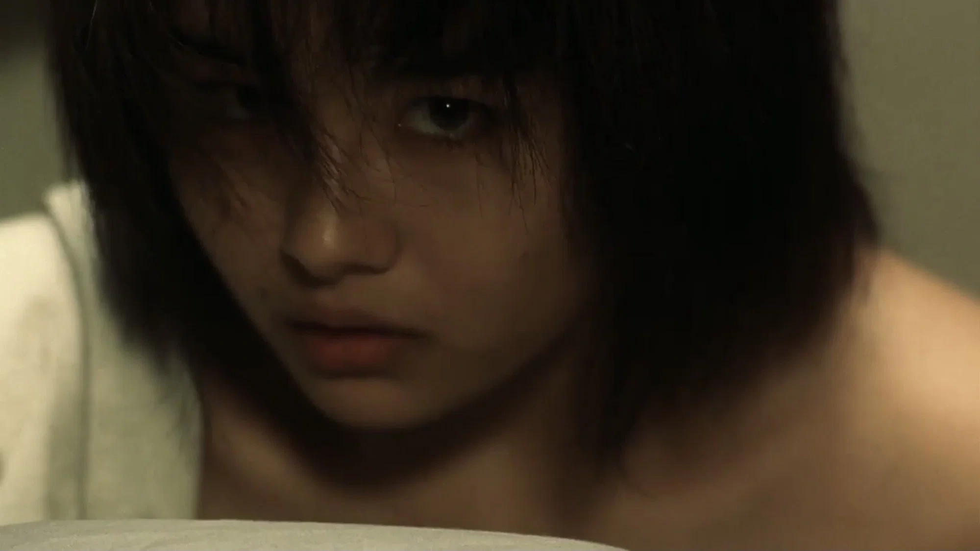 لقطة قريبة لكونيكو تنظر جانبًا بتعبير متوتر داخل إضاءة خافتة